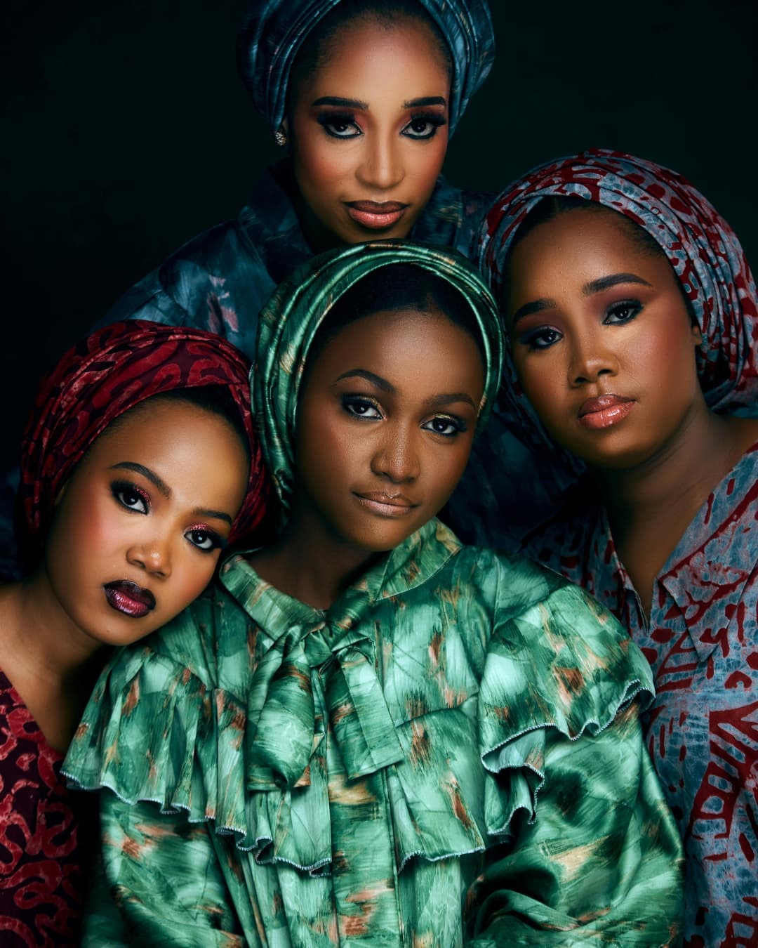 Four women in colorful headwraps