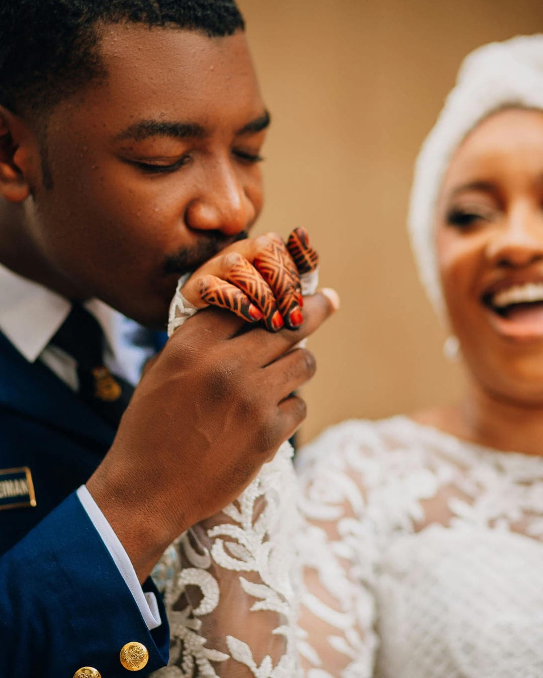 Groom kissing bride's henna-decorated hand
