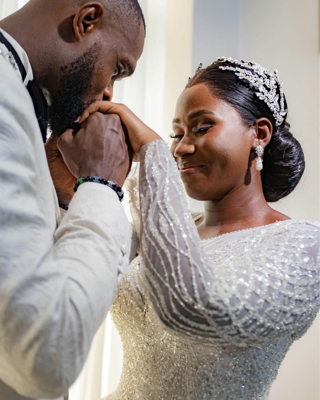 Groom kissing bride with tiara